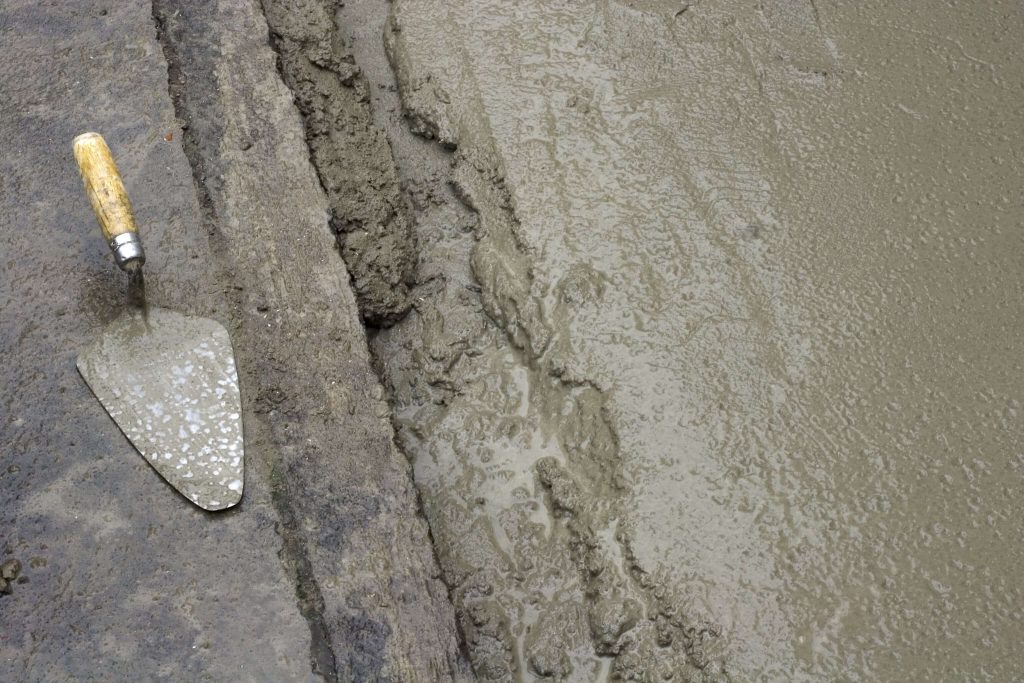 close up of a cement trowel and concrete drying